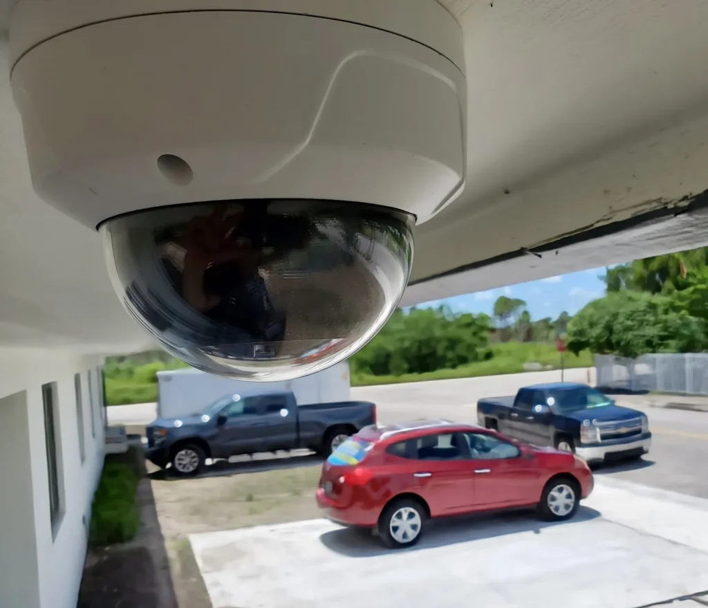 Cámara de seguridad domo instalada bajo el alero de una vivienda.